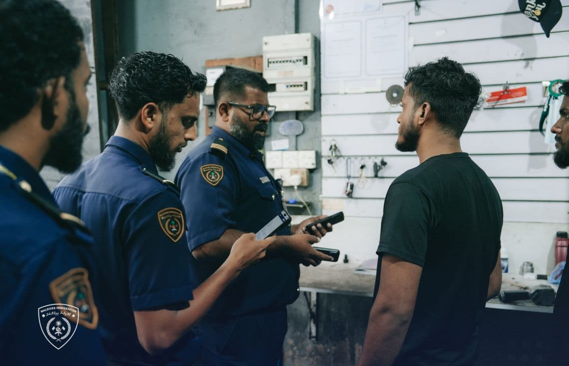 އިމިގްރޭޝަންގެ އޮފިސަރުން ބިދޭސީއަކާ ސުވާލުކުރަނީ / ފޮޓޯ: އިމިގްރޭޝަން