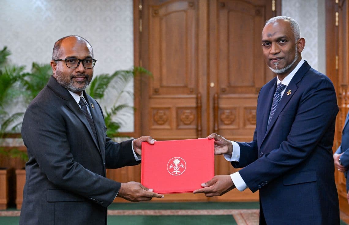 ހޯމް މިނިސްޓަރު އަލީ އިހުސާނަށް މަގާމުގެ ފަތްކޮޅު އަރުވަނީ. / ފޮޓޯ: ރައީސް އޮފީސް