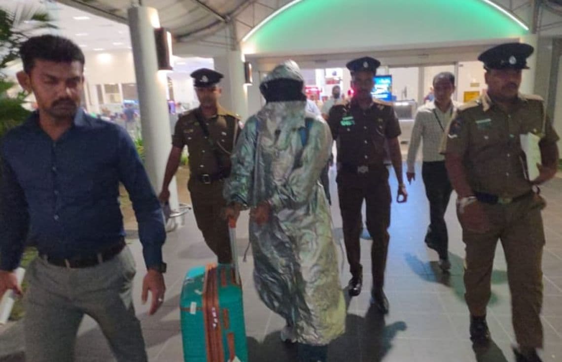 ރާއްޖެއިން ފޮނުވައިލި މީހާ ލަންކާގެ ބަންޑާރަނައިކަ އެއާޕޯޓަށް ދިޔުމާއެކު، ލަންކާގެ ސީއައިޑީ އިން އޭނާ ހައްޔަރުކޮށްގެން ގެންދާ މަންޒަރު.