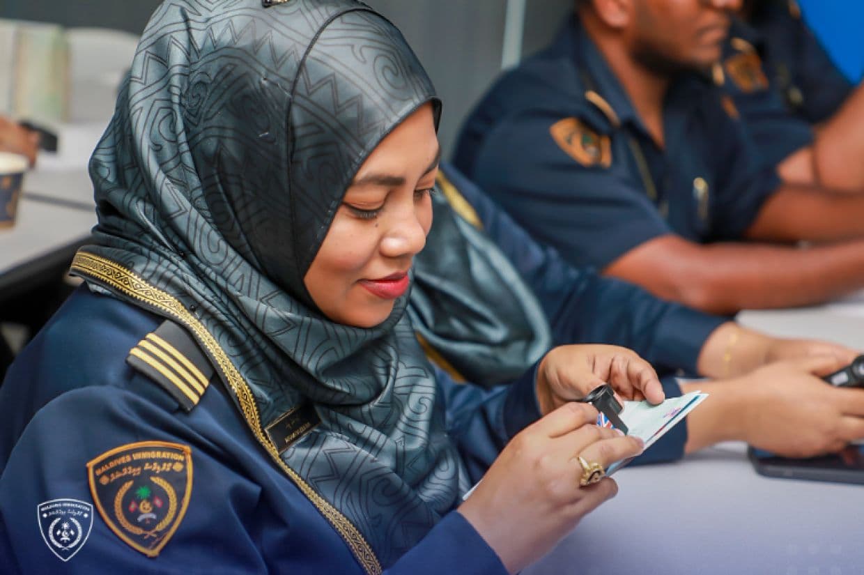 އިމިގްރޭޝަނުން ޕާސްޕޯޓު ޗެކް ކުރަނީ. / ފޮޓޯ: އިމިގްރޭޝަން
